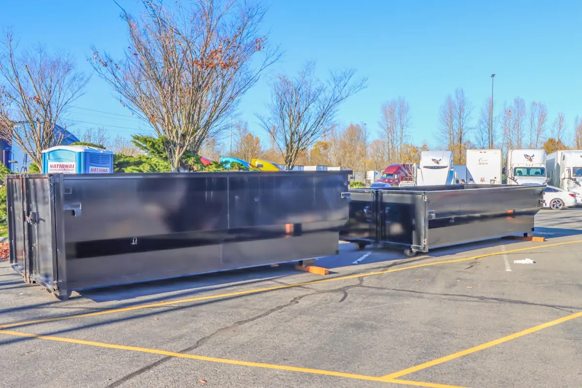 Professional dumpster rental service with roll-off container on residential driveway in Roy